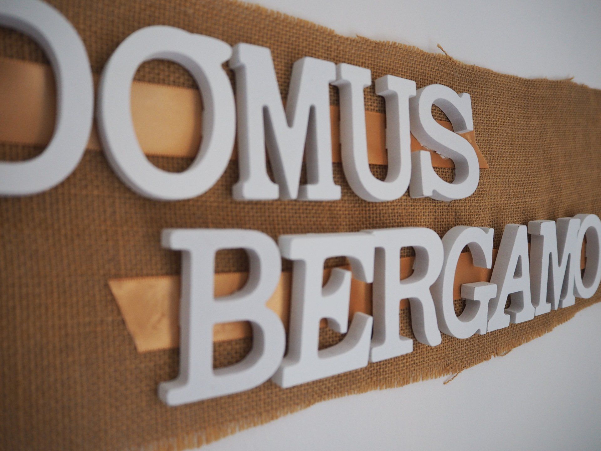 Close-up of a decorative wooden sign with the raised white text 