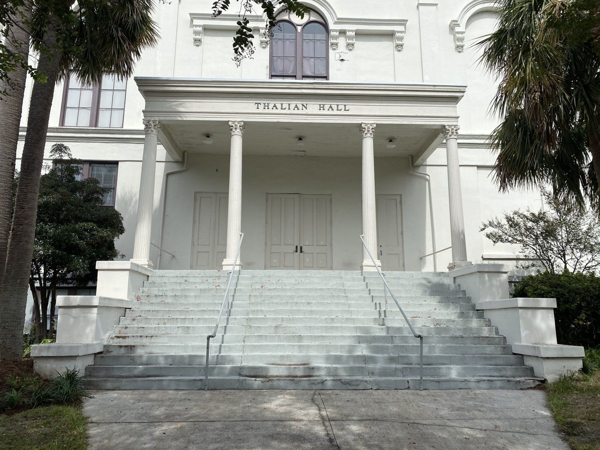 White historic building entrance with central steps, columns, and “ITALIAN HALL” above the doorway