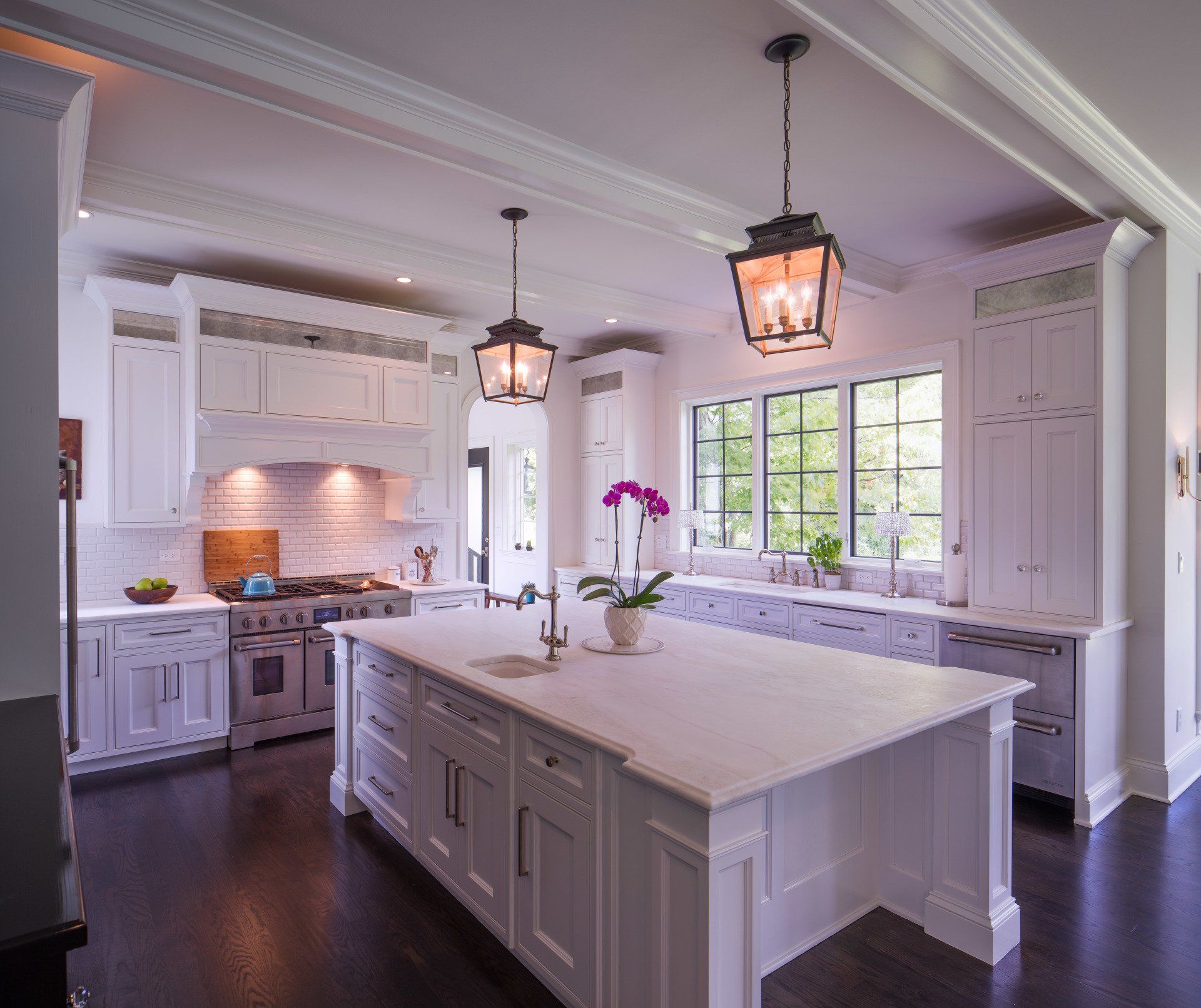 A kitchen with white cabinets and a large island
