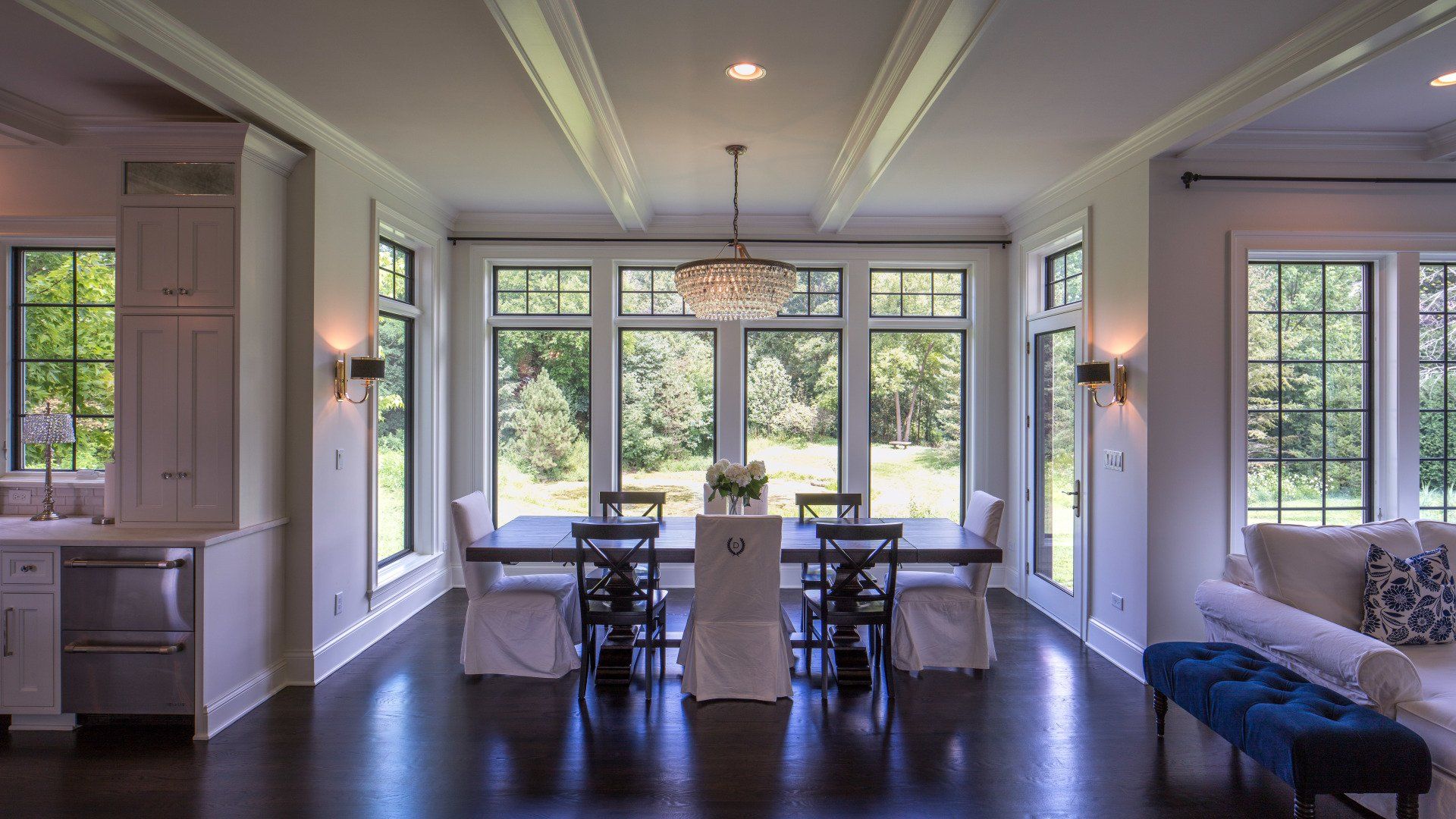 A large dining room with a table and chairs and lots of windows.