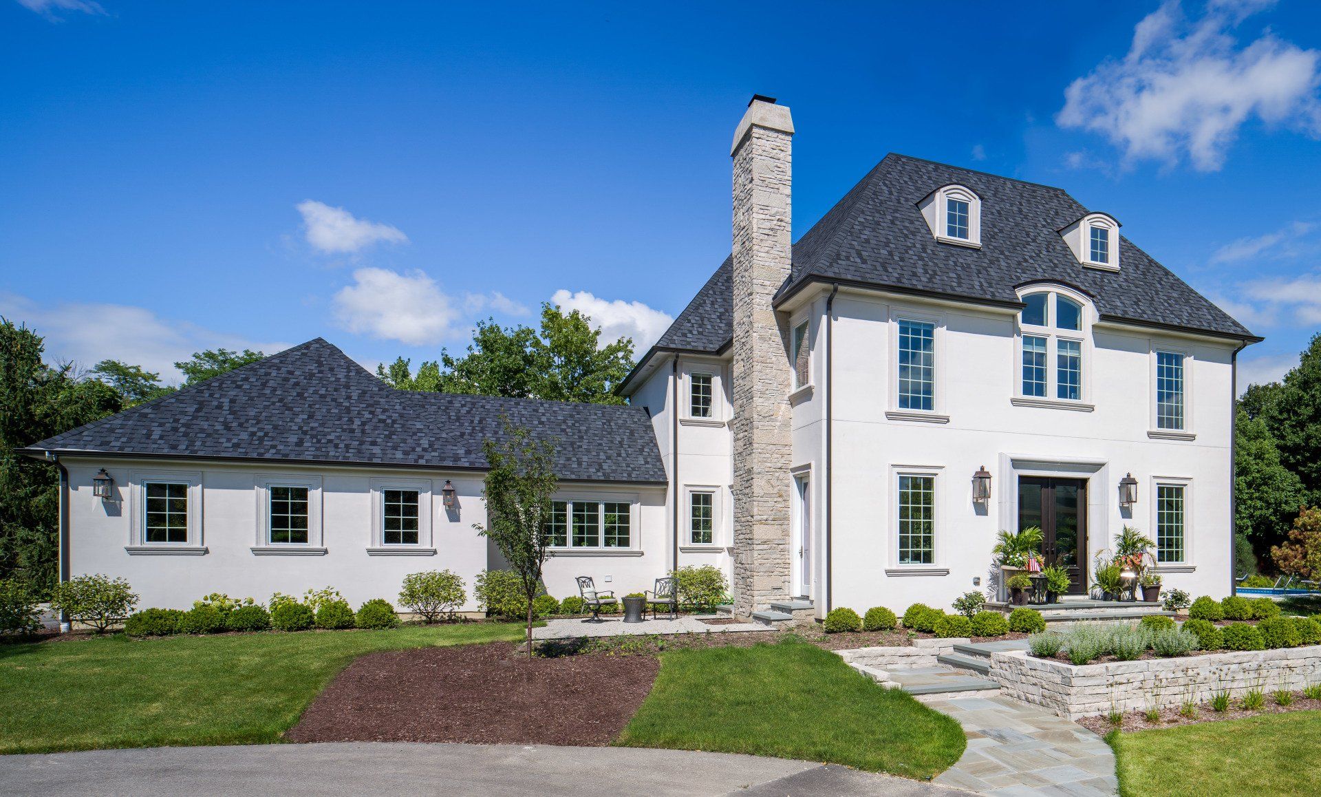 A large white house with a black roof and a chimney