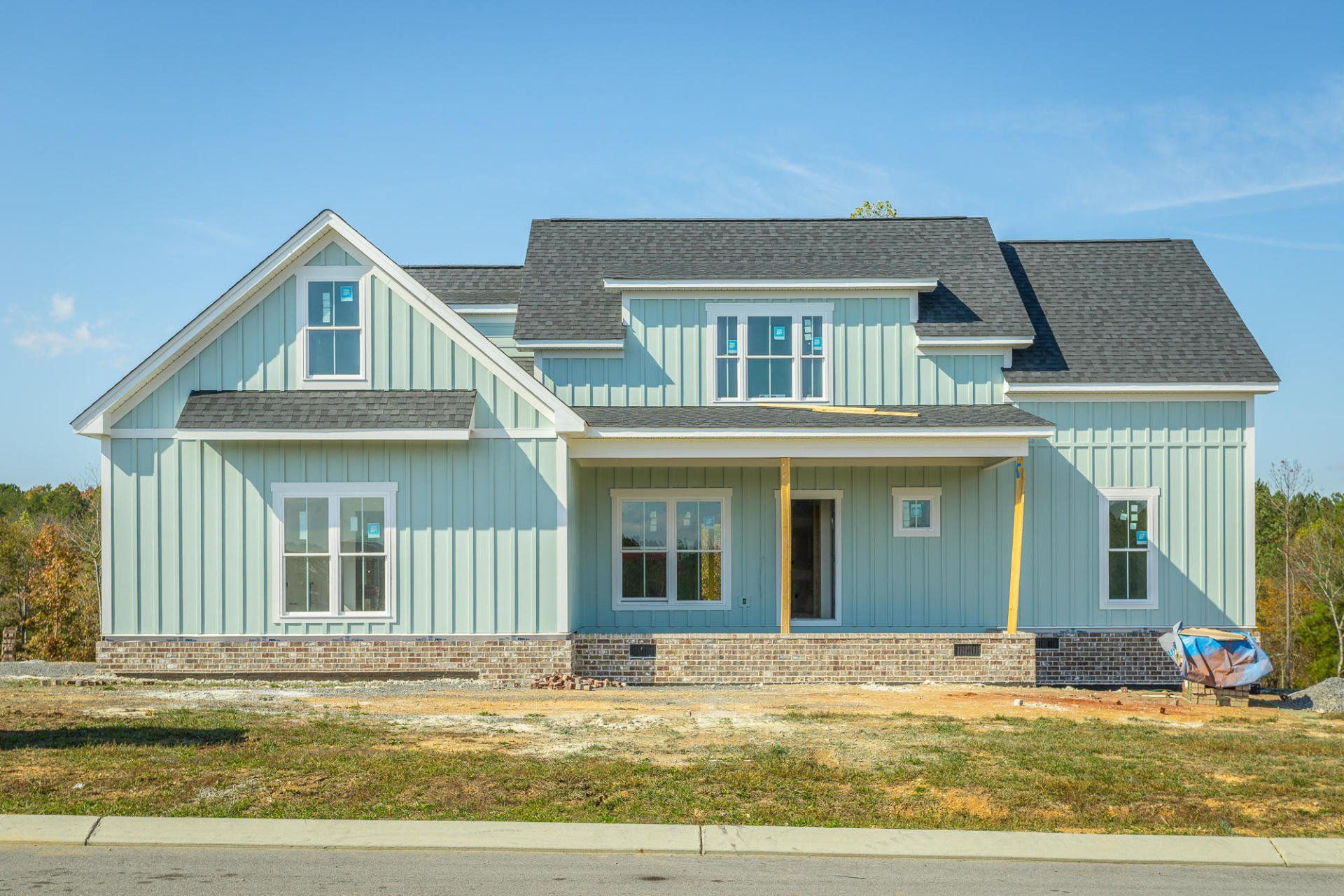 a large blue house with a black roof is being built .