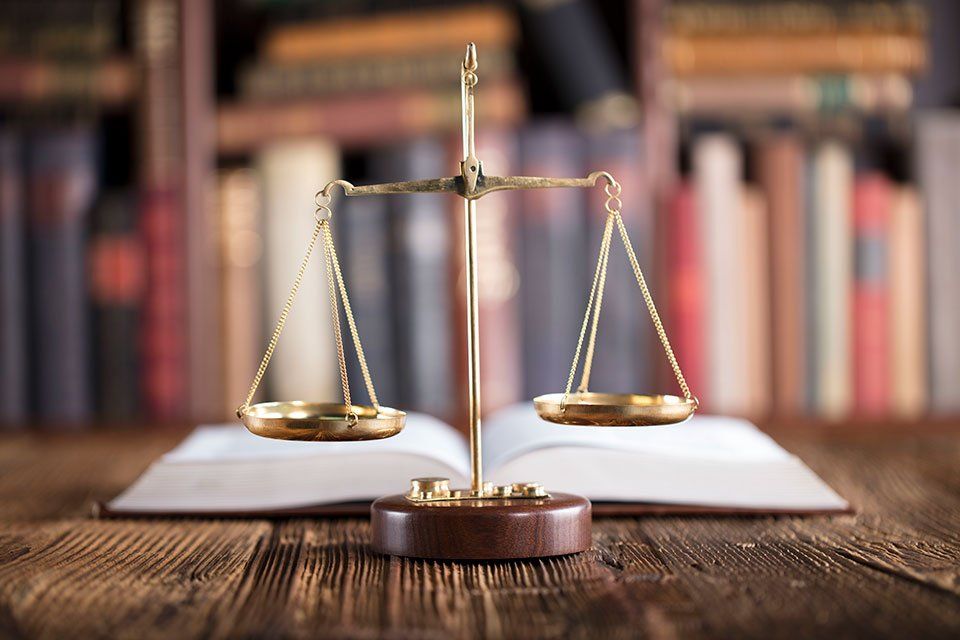 bilancia dorata giustizia con codice di diritto