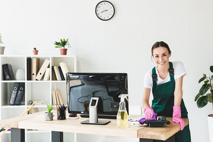 A housekeeping cleaner smiling while on a commercial cleaning service