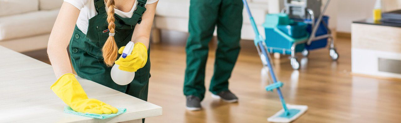 A cleaner using a floor cleaning machine to wipe the floor during a commercial cleaning  job