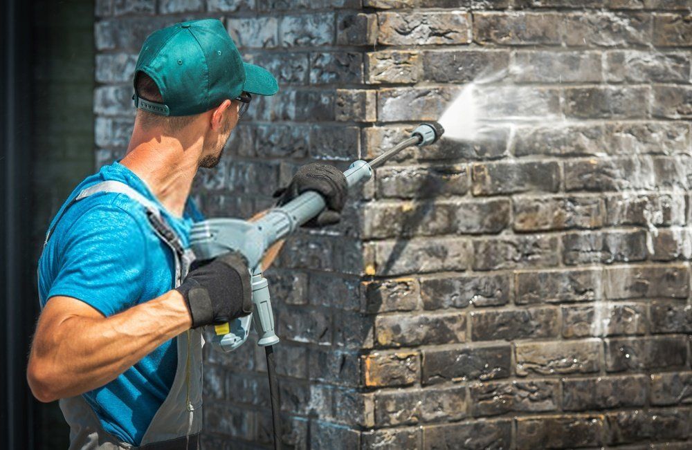 A cleaner holding a pressure steam equipment while wall cleaning