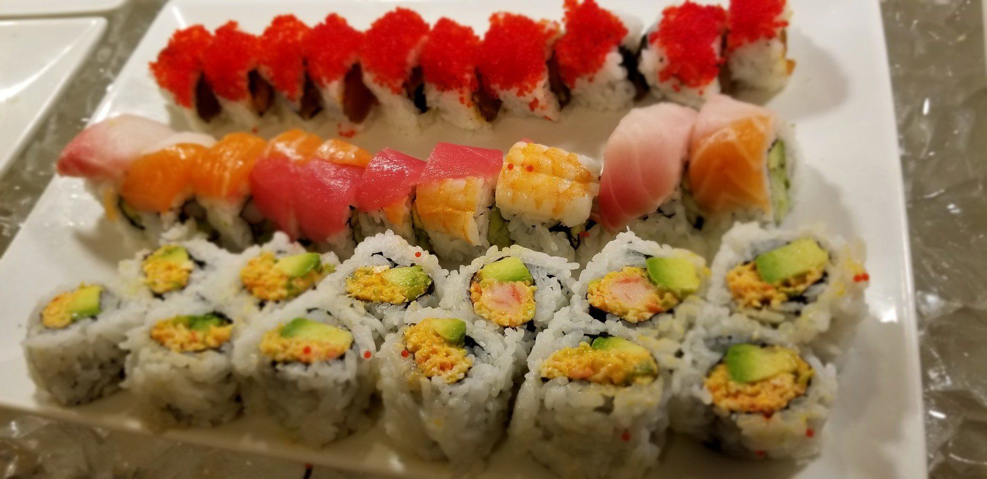 Hibachi Grill — Hand Picking Up Sushi Roll with Chopsticks in Chico, CA Hibachi Grill — Hand Picking Up Sushi Roll with Chopsticks in Chico, CA