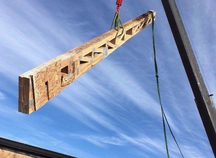 New roof truss being delivered by crane to rooftop Lakeview, Chicago