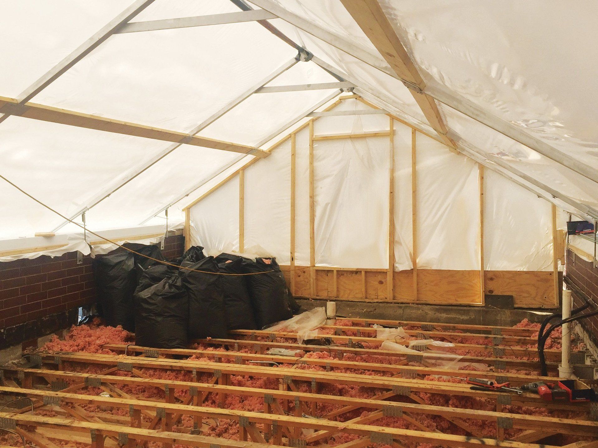 Construction tent covering flat roof undergoing truss repairs