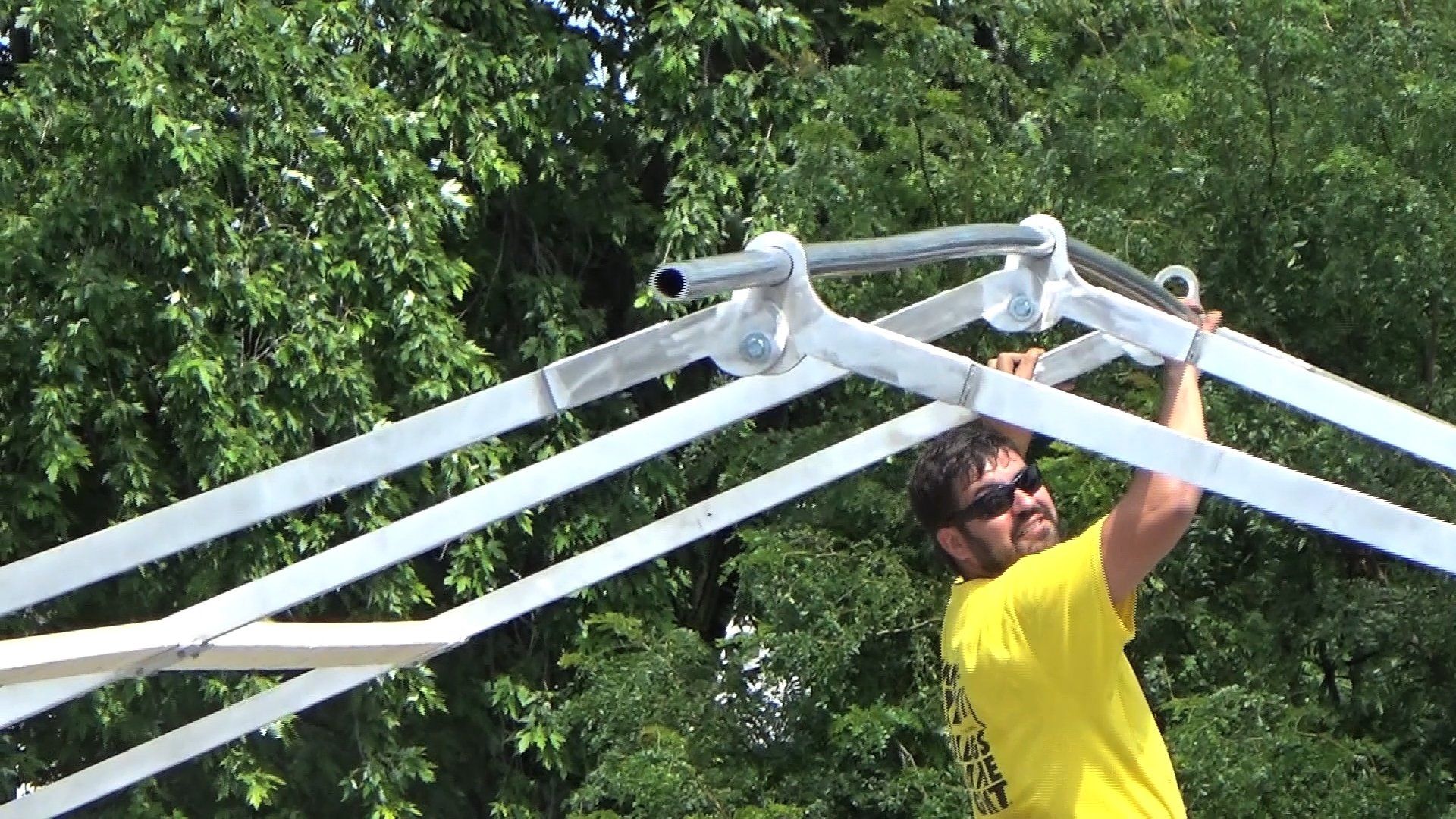 Worker assembling a metal frame for construction tent