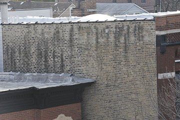 Brick building wall with marks of moisture accumulation