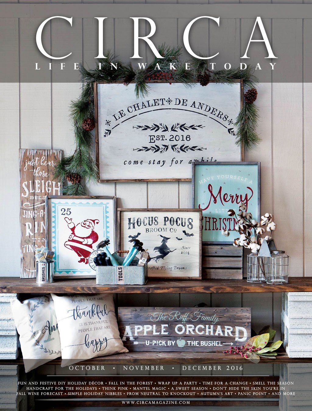 Magazine cover: Rustic Christmas decor on a shelf, featuring framed signs and greenery.