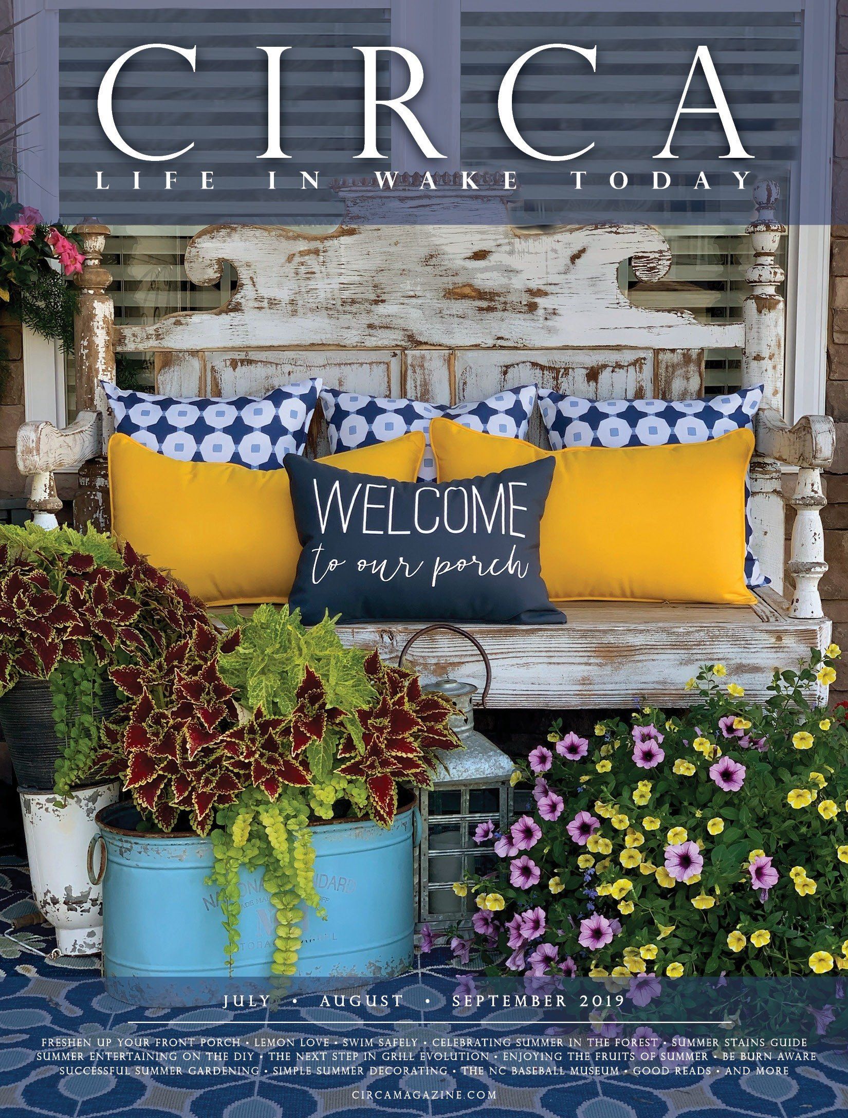 Porch scene with a weathered bench, pillows, plants, and the word 