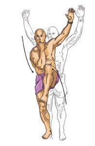 Man performing a standing knee lift, arm raised overhead, other arm bent at elbow.