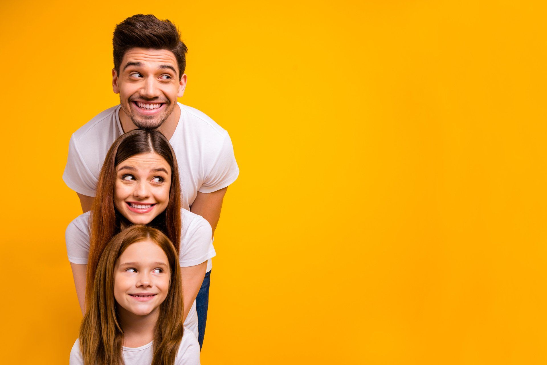 Family stacked vertically, smiling with a yellow background.