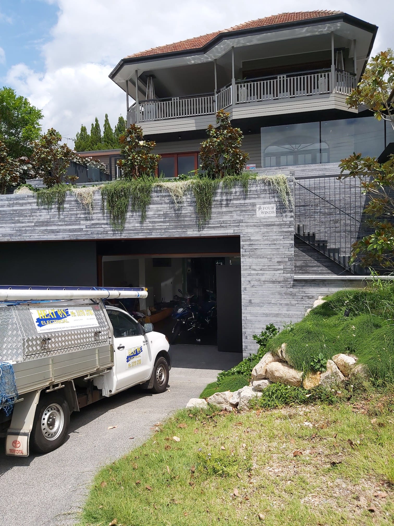 A white truck is parked in front of a large house.