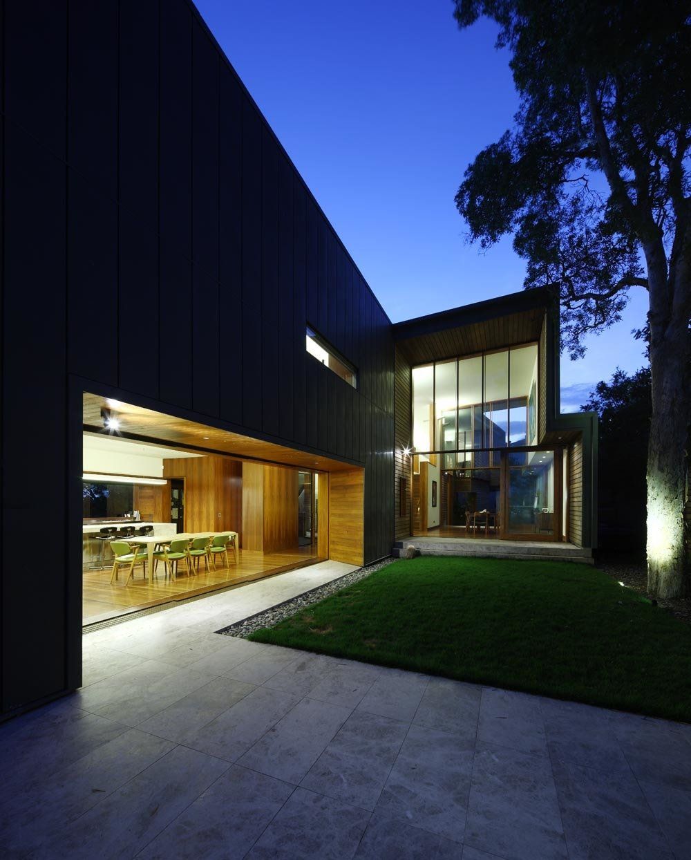 A large house with a lot of windows is lit up at night