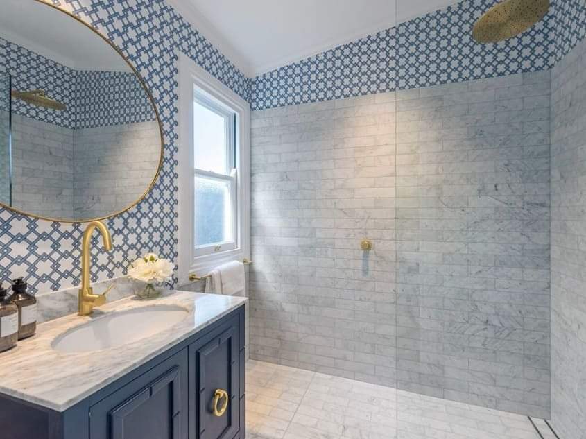 A bathroom with a sink , mirror and walk in shower.