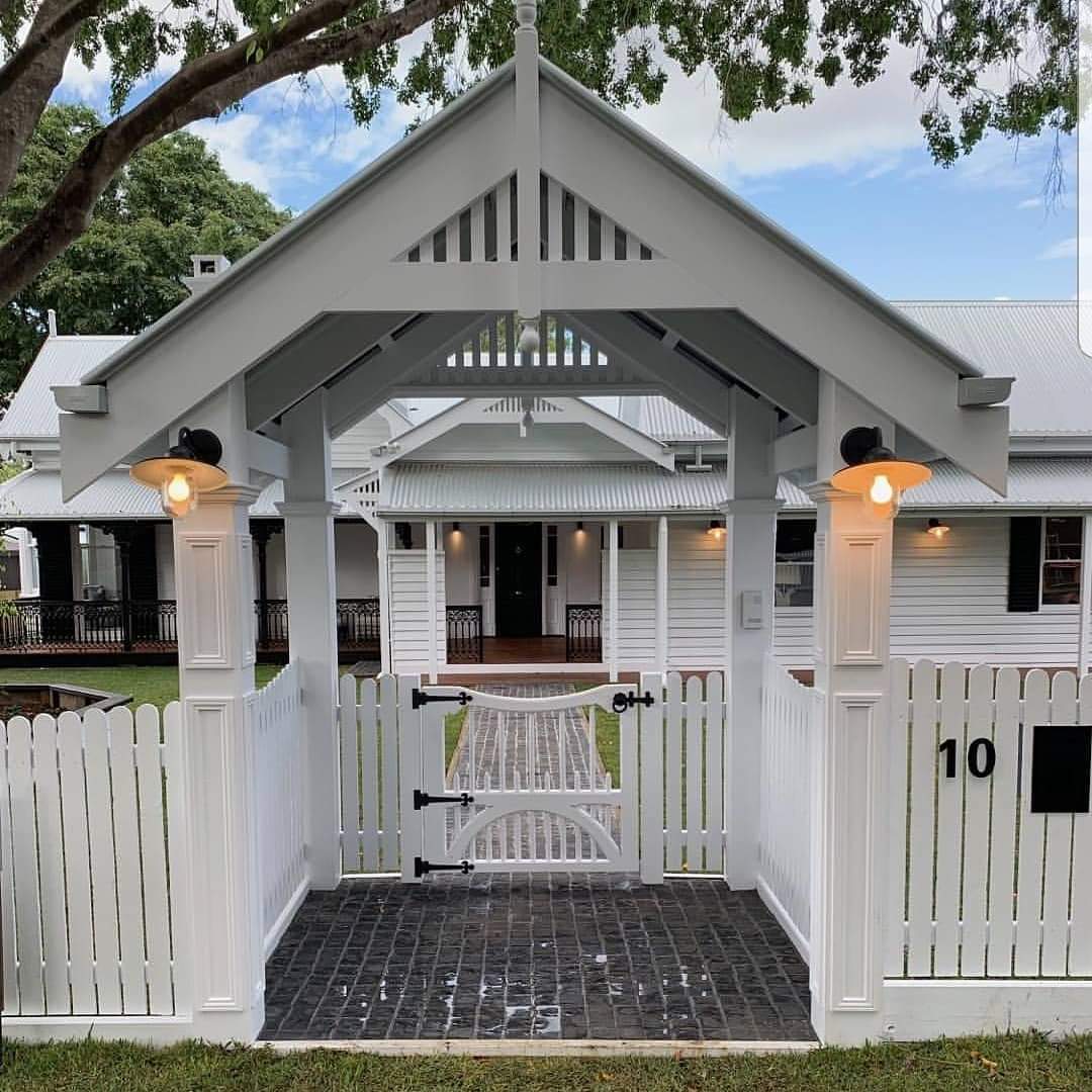 A white house with a white fence and a gate