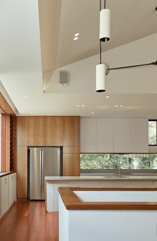 A kitchen with white cabinets and a stainless steel refrigerator
