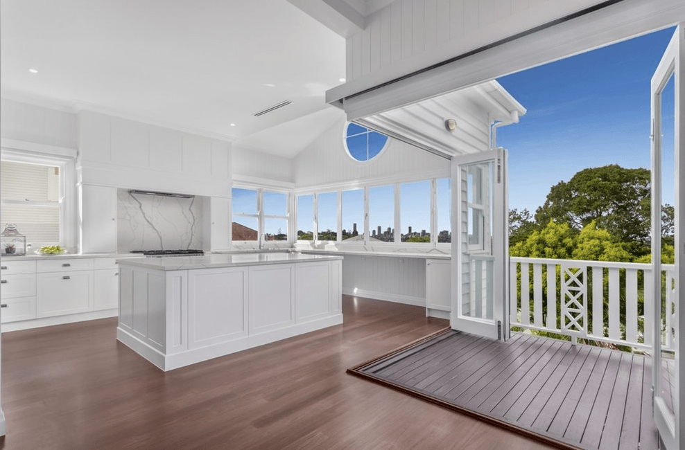 A kitchen with a large island and a balcony