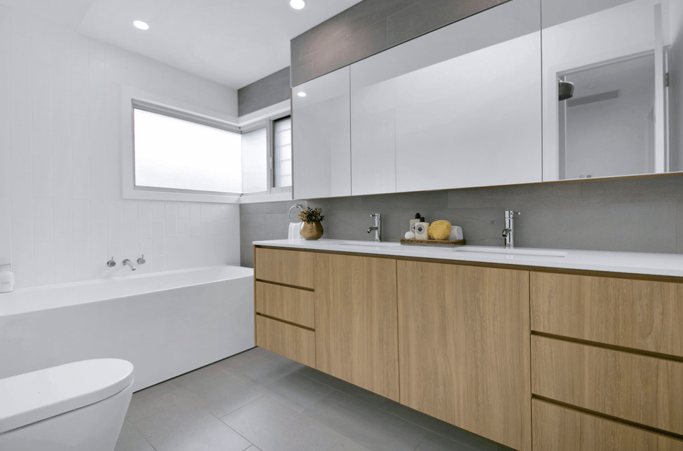 A bathroom with two sinks , a toilet , and a bathtub.