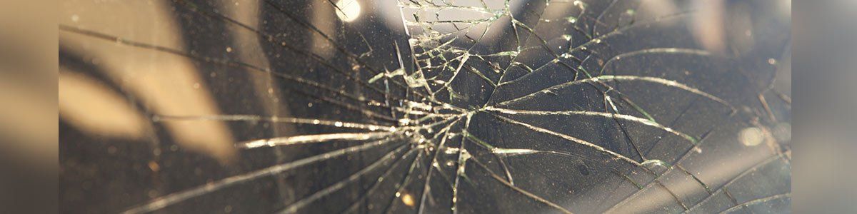 Cracked glass screen with multiple radial fractures, possibly from a phone or tablet.