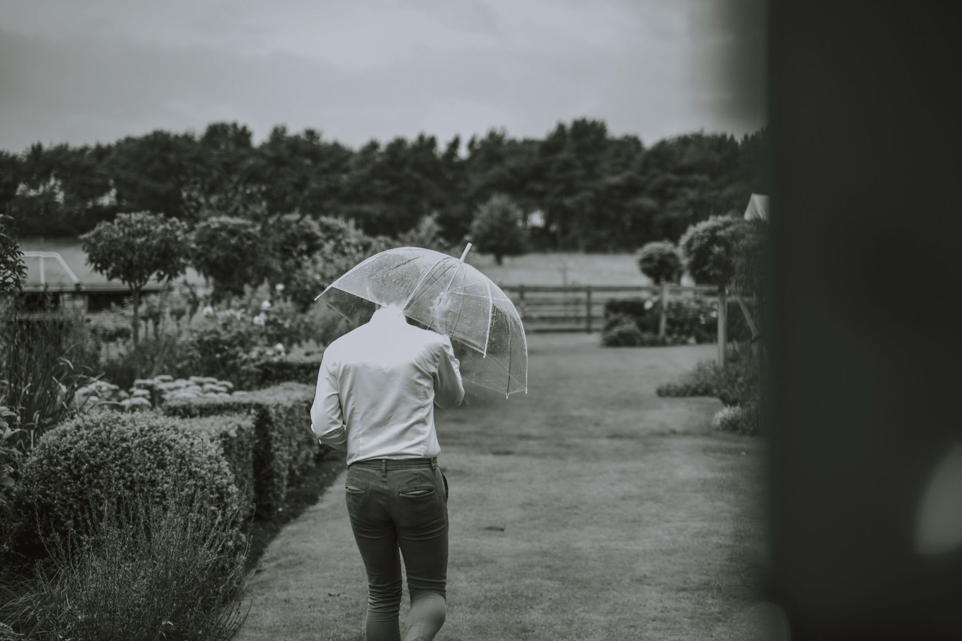 A man is running with an umbrella in the rain.