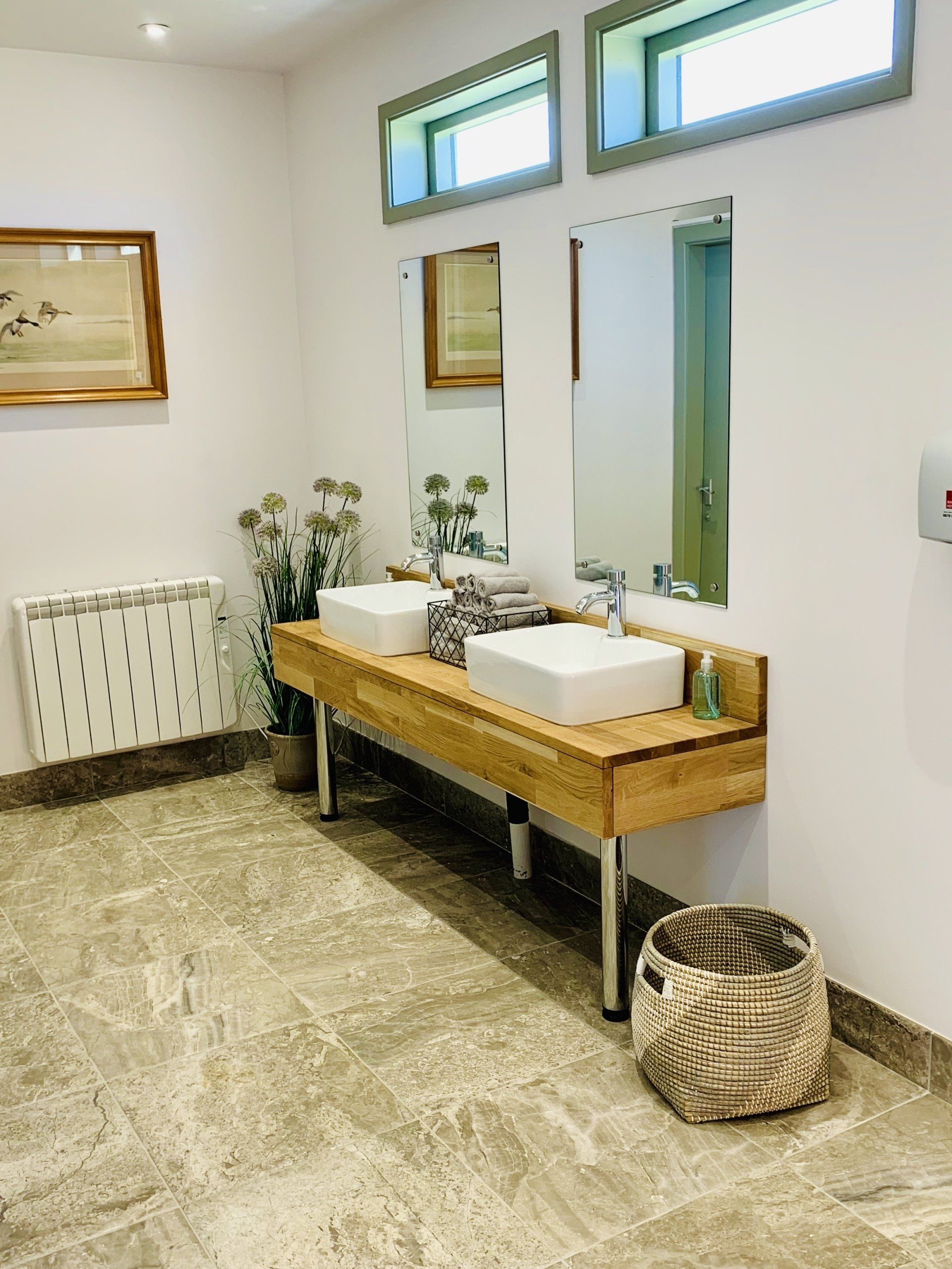 A bathroom with two sinks and two mirrors.