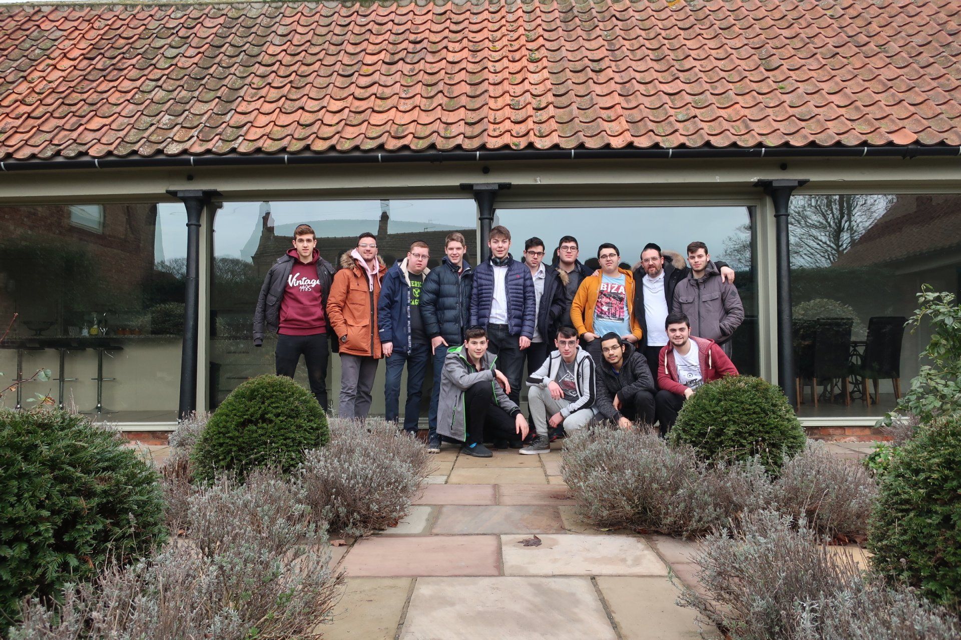 A group of young men are posing for a picture in front of a building.