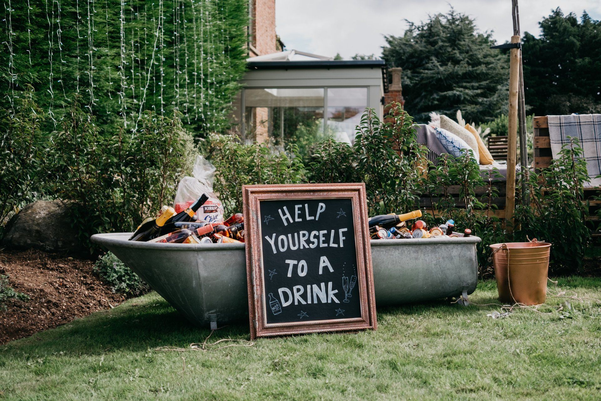 A sign in front of a bathtub that says `` help yourself to a drink ''.