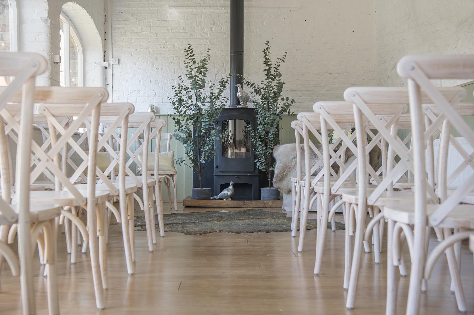 A room filled with white chairs and a fireplace.