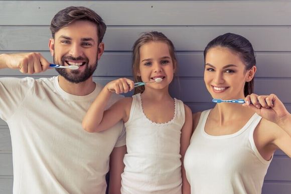 Family holding toothbrush - Family dentistry in Mount Holly, NJ Family holding toothbrush - Family dentistry in Mount Holly, NJ