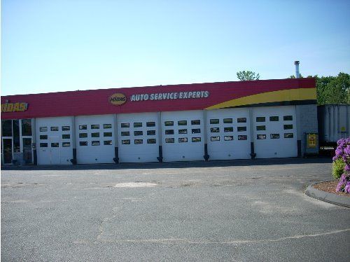 Red and yellow Midas Auto Service Express building with multiple garage doors.