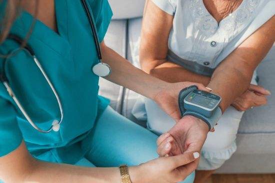 medico che controlla pressione del polso di un paziente