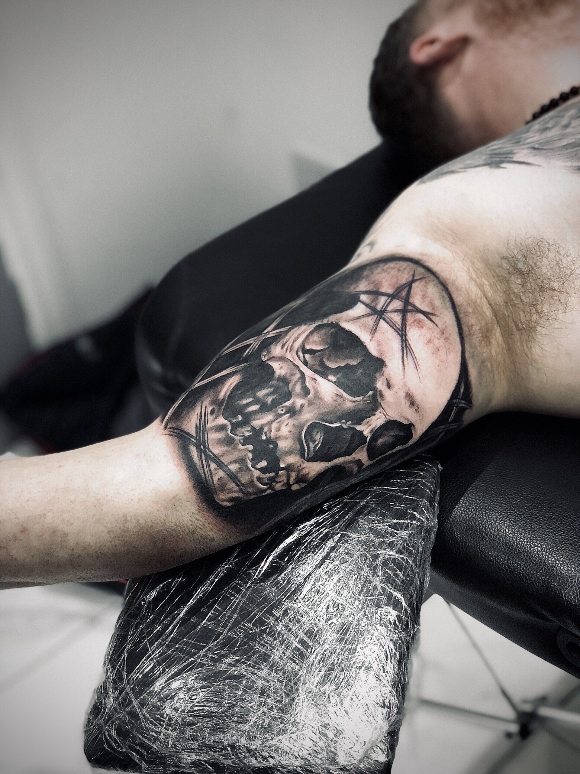 A man has a tattoo of a skull on his arm