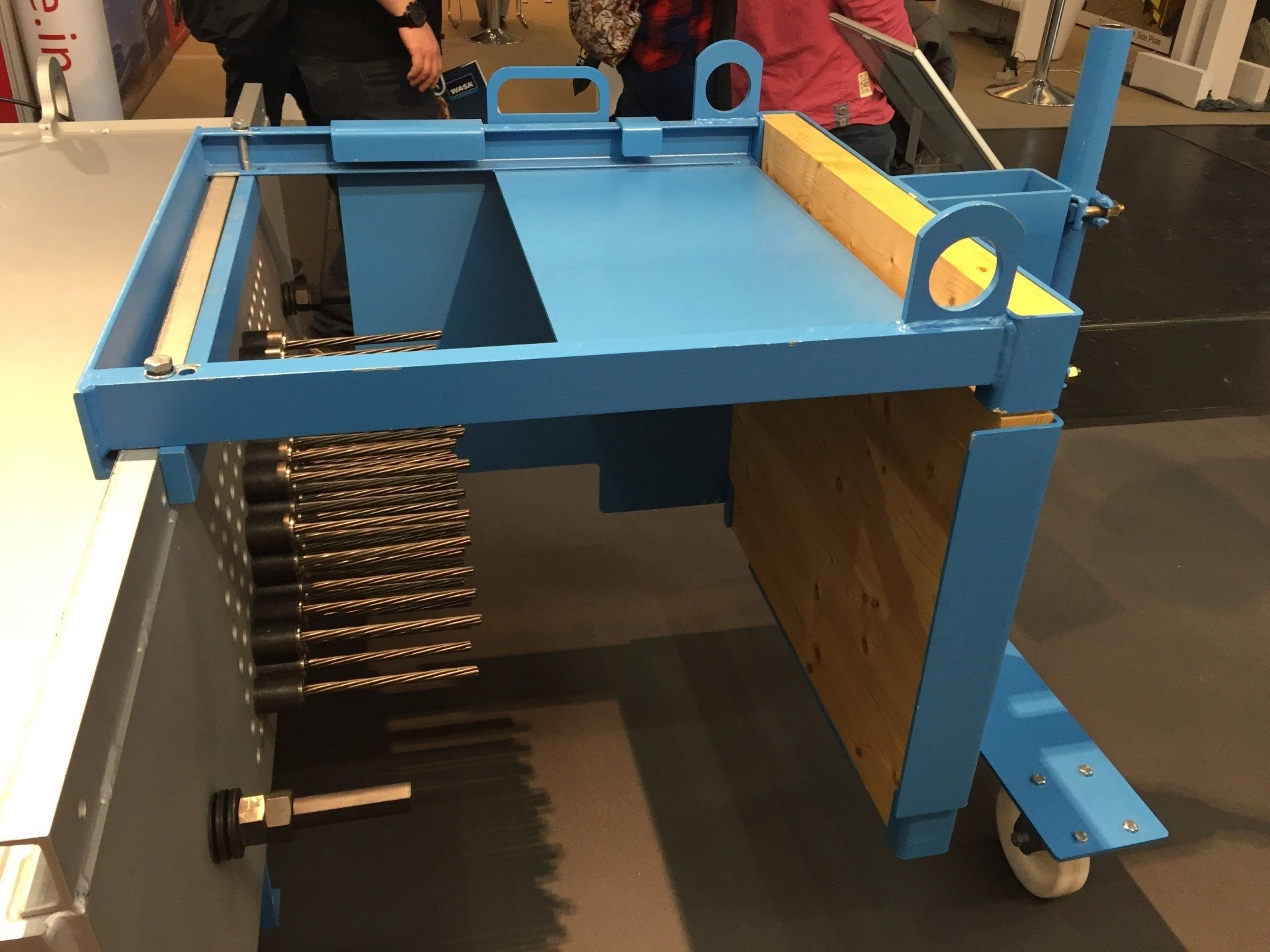Blue metal rolling cart with a top platform and drawers, shown in a workshop setting