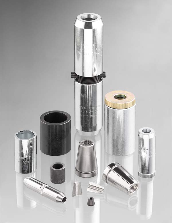 Assorted metal and plastic cylindrical industrial parts arranged on a white surface