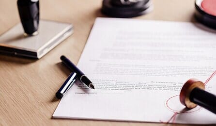 Papers, pens, and stamps scattered on a table - Orlando, Florida - Law Offices of Amber Jade Johnson, PA Papers, pens, and stamps scattered on a table - Orlando, Florida - Law Offices of Amber Jade Johnson, PA