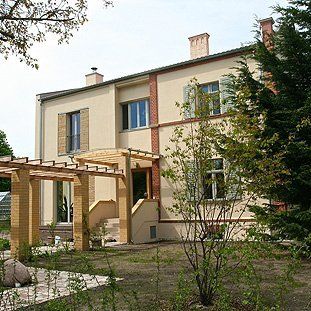 Ein großes Haus mit einer Pergola davor