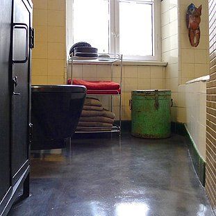 Ein Badezimmer mit einem grünen Eimer auf dem Boden