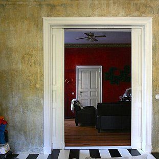 Ein Wohnzimmer mit roten Wänden und einem schwarz-weiß gestreiften Boden
