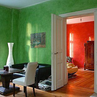 Ein Wohnzimmer mit grünen Wänden und einem Tisch und Stühlen
