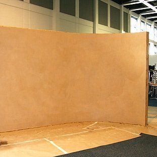 In der Mitte eines Raumes steht eine große Holzwand.