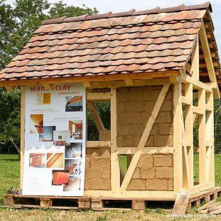 Eine Holzkonstruktion mit einem Dach aus Lehm
