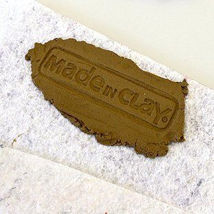 Ein Stück brauner Ton mit der Aufschrift „Aus Ton gemacht“.