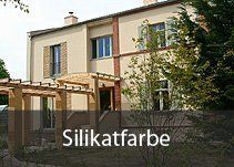 Ein großes Haus mit einer Pergola und einem Schild mit der Aufschrift „Silikatfarbe“.