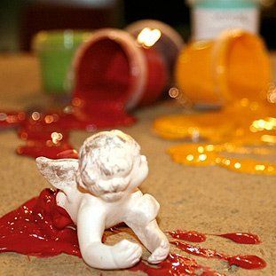 Eine Statue eines Cherubs liegt auf dem Boden, bedeckt mit Farbe