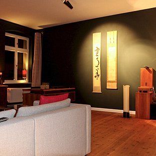Ein Wohnzimmer mit einer Couch und zwei Gemälden an der Wand