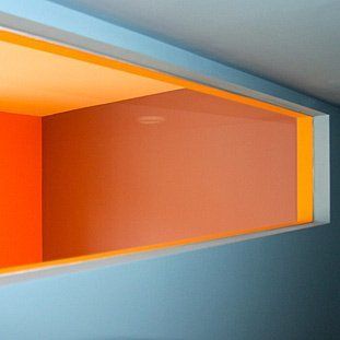 Ein Fenster in einem Raum mit orangefarbenen und gelben Wänden